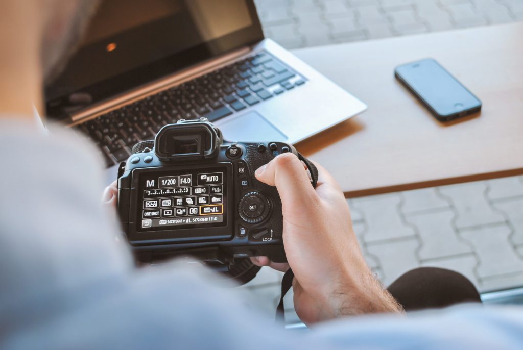 man changing settings on DSLR camera branded video content ideas
